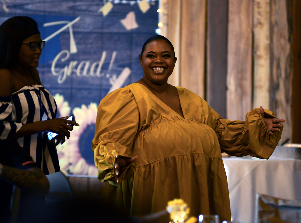 Tyus Monroe grins at guests at her graduation party